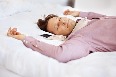 Tired young businessman comfortably sleeping in his bed