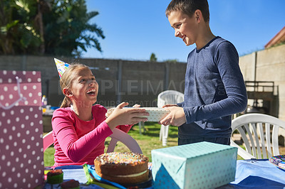 Buy stock photo Shot of the birthday girl receiving a present from a party guest