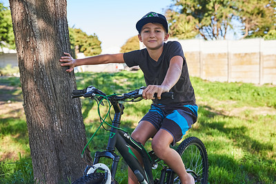 Buy stock photo Cropped portrait of a young boy riding his bike outside