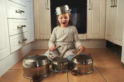 Buy stock photo Shot of a little girl playing drums on a set of pots in the kitchen