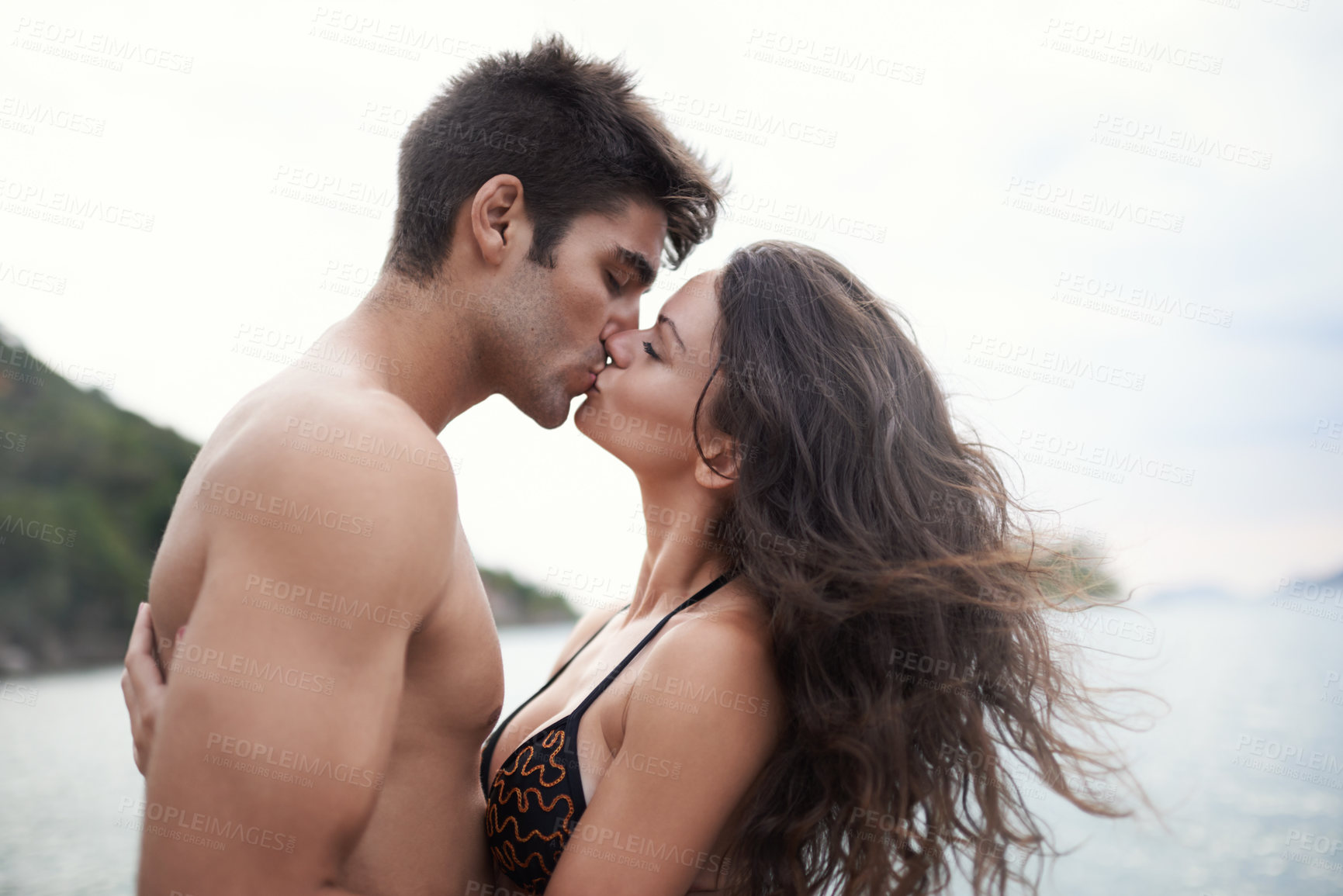 Shot of an intimate young couple enjoying a vacation by the sea - stock pho...