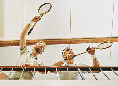 Buy stock photo Shot of two young men watching a game of squash from the viewing gallery