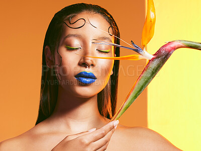 Buy stock photo Studio shot of a beautiful young woman posing with a strelitzia flower