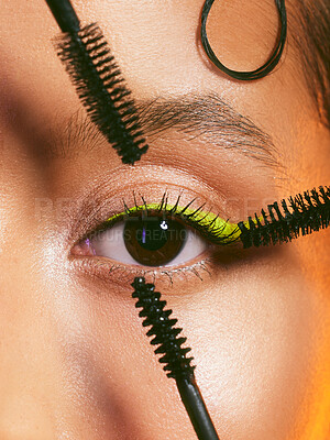 Buy stock photo Shot of a beautiful young woman posing with multiple mascara brushes around her eye