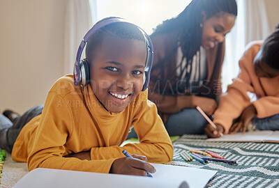 Buy stock photo Shot of a young boy completing school work while listening to music