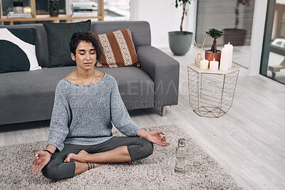 Buy stock photo Shot of an attractive young woman meditating on the lounge floor at home
