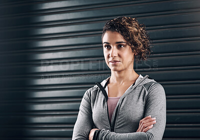 Buy stock photo Shot of a young beautiful woman folding her arms against a black background