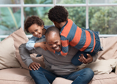 Buy stock photo Shot of a father playing with his two little sons on a sofa at home