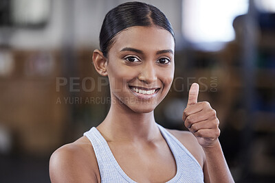 Buy stock photo Portrait of a sporty young woman showing thumbs up in a gym