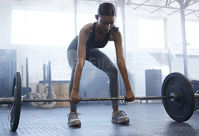 Buy stock photo Shot of a sporty young woman exercising with a barbell in a gym
