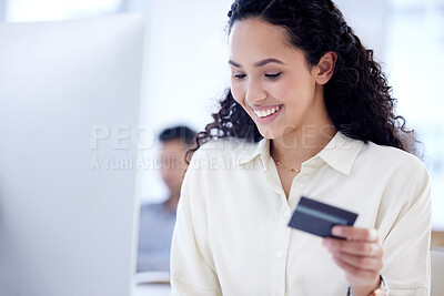 Buy stock photo Shot of a young businesswoman using a credit card and computer in an office