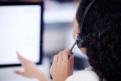 Buy stock photo Rearview shot of a call centre agent working on a computer in an office