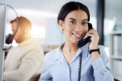 Buy stock photo Shot of an attractive young call centre agent sitting with her colleague in the office and using a telephone