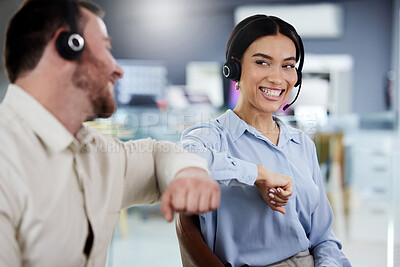 Buy stock photo Shot of a young call centre agent sitting with a colleague in the office and giving him an elbow bump