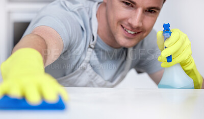 Buy stock photo Shot of a young man cleaning his kitchen counter