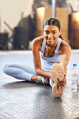 Buy stock photo Portrait of a fit young woman stretching in a gym