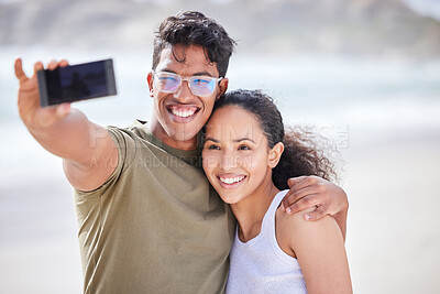 Buy stock photo Shot of a young couple taking a selfie at the beach