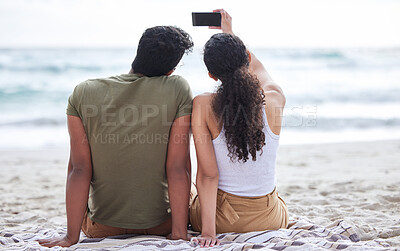Buy stock photo Shot of a young couple taking a selfie at the beach