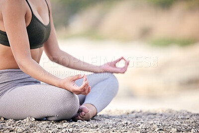 Buy stock photo Cropped shot of a woman meditating while sitting at the beach
