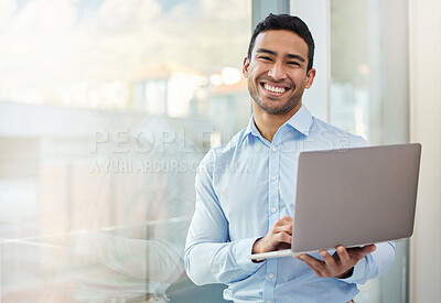 Buy stock photo Shot of a young businessman using his laptop in his office