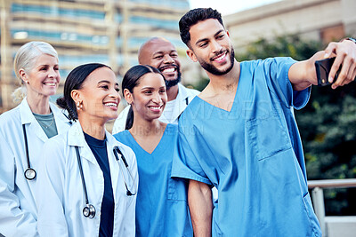 Buy stock photo Shot of a group of doctors taking a selfie in the city