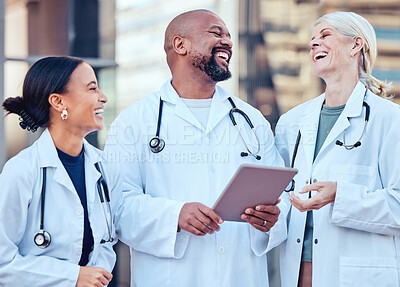 Buy stock photo Shot of a group of doctors using a digital tablet in the city