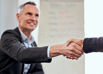 Buy stock photo Shot of a mature businessman shaking hands with a coworker at work