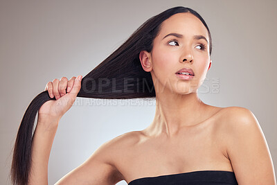 Buy stock photo Shot of an attractive young woman posing alone in the studio and holding her hair