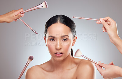 Buy stock photo Studio portrait of a beautiful young woman having makeup applied to her face against a grey background