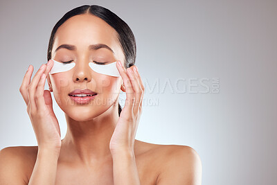 Buy stock photo Studio shot of a beautiful young woman wearing under-eye patches against a grey background