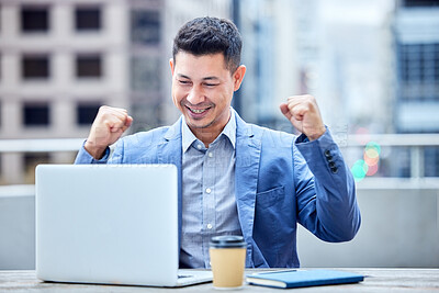 Buy stock photo Shot of a young businessman cheering while using a laptop at work