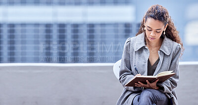 Buy stock photo Shot of a young businesswoman writing in a notebook at work
