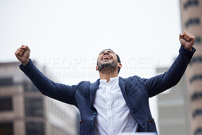 Buy stock photo Cropped shot of a handsome young businessman standing outside in the city with his arms raised in jubilation