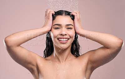 Buy stock photo Shot of a young woman rinsing her hair against a studio background