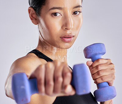 Buy stock photo Shot of an attractive young woman standing and posing with dumbbells during her workout