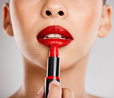 Buy stock photo Studio shot of an attractive young woman applying red lipstick against a grey background