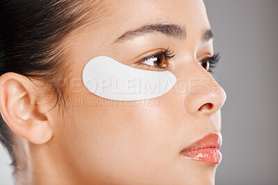 Buy stock photo Studio shot of an attractive young woman wearing an under eye patch against a grey background