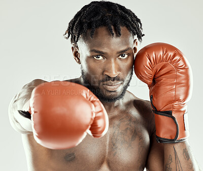 Buy stock photo Studio shot of a muscular young man wearing boxing gloves