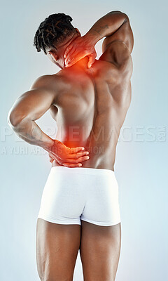 Buy stock photo Studio shot of a muscular young man experiencing back pain
