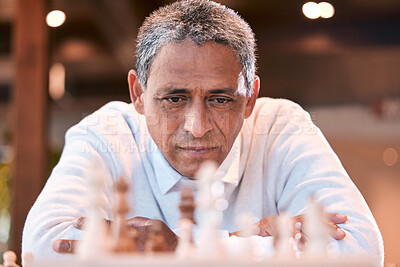 Buy stock photo Shot of a senior man sitting alone and feeling contemplative while playing chess