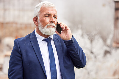 Buy stock photo Shot of a senior businessman using a smartphone against an urban background