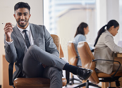 Buy stock photo Shot of a handsome young businessman sitting in an office