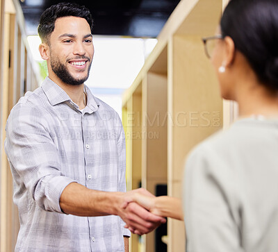 Buy stock photo Cropped shot of a handsome young businessman shaking hands with a female colleague in the office