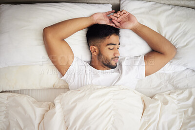 Buy stock photo Shot of a young man sleeping in a bed at home