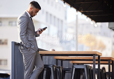 Buy stock photo Cropped shot of a handsome young businessman checking his messages while waiting to be seated at an internet cafe in the city