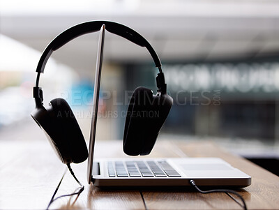 Buy stock photo Full length shot of a laptop and headphones outside on a table at an internet cafe