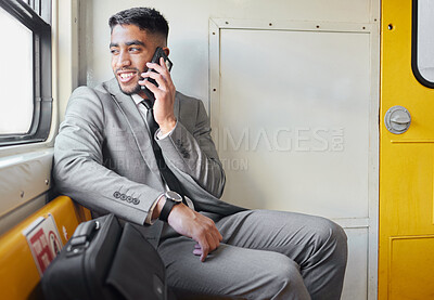 Buy stock photo Shot of a young businessman talking on a cellphone while staring out the window on a train during his commute