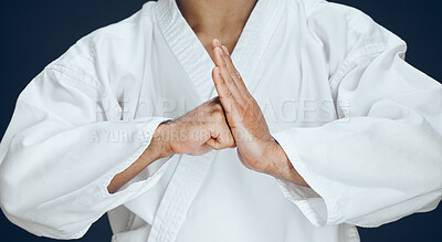 Buy stock photo Cropped shot of an unrecognizable male martial artist practicing karate in studio against a dark background