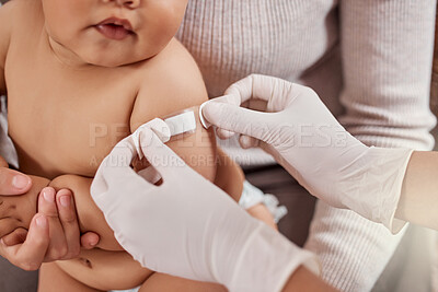 Buy stock photo Shot of a doctor applying a plaster on a baby's arm