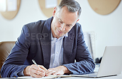 Buy stock photo Shot of a mature businessman writing in a diary in an office at work